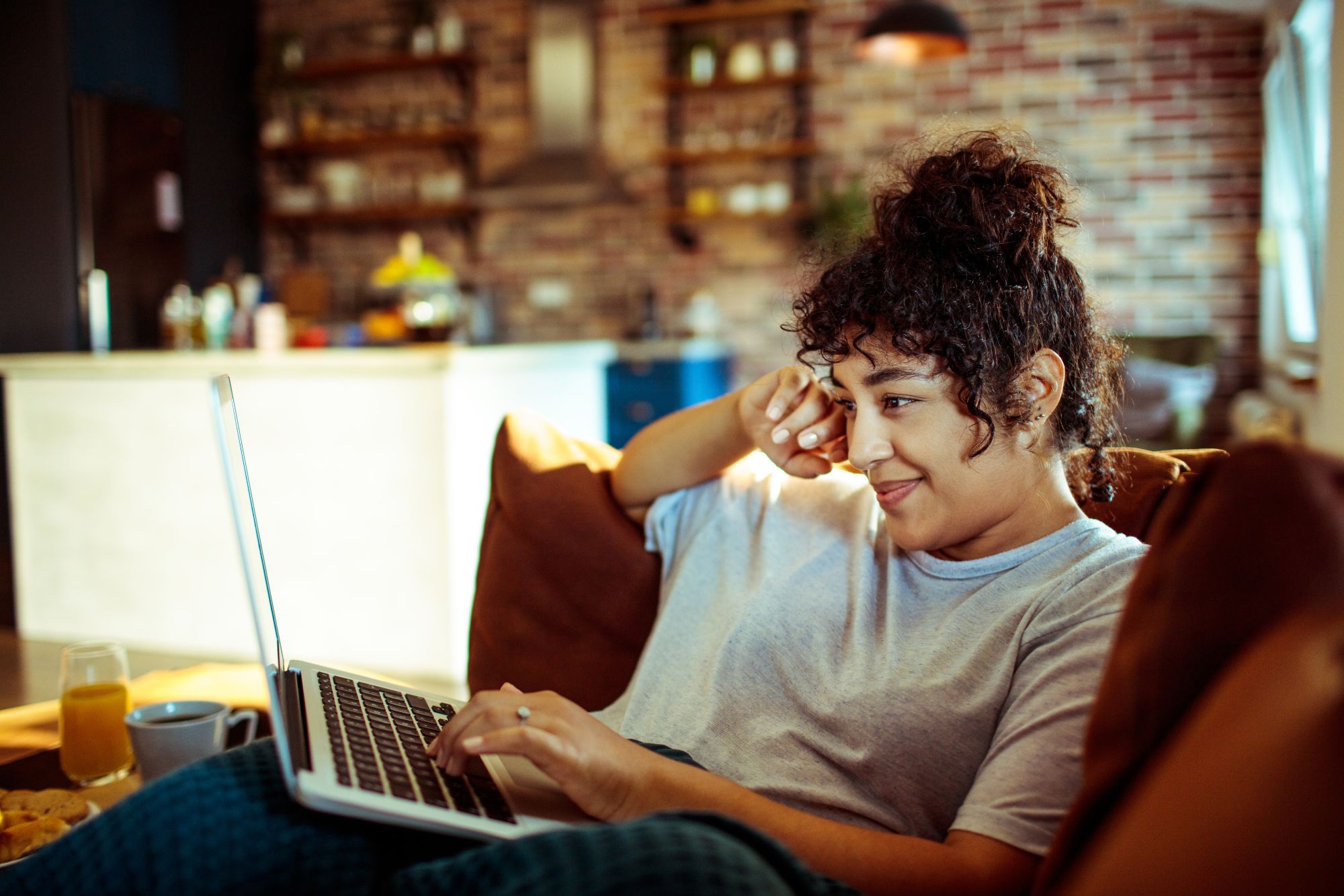 Close up of a young woman using a laptop at home